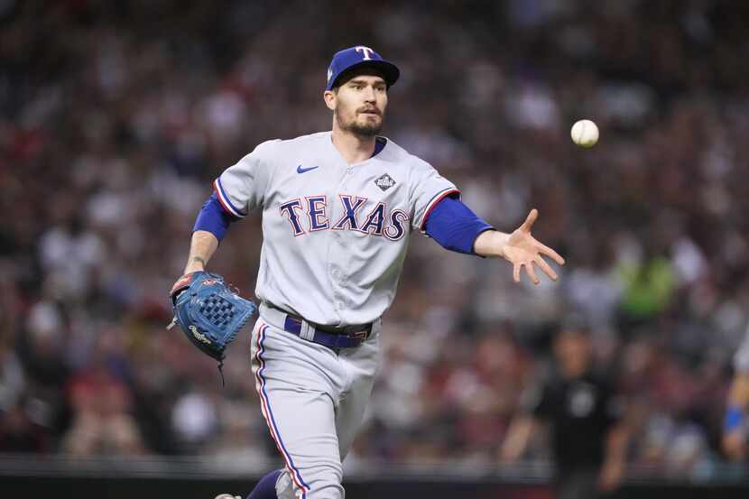 Texas Rangers pitcher Andrew Heaney (44) tosses to first for the final out during the fifth...
