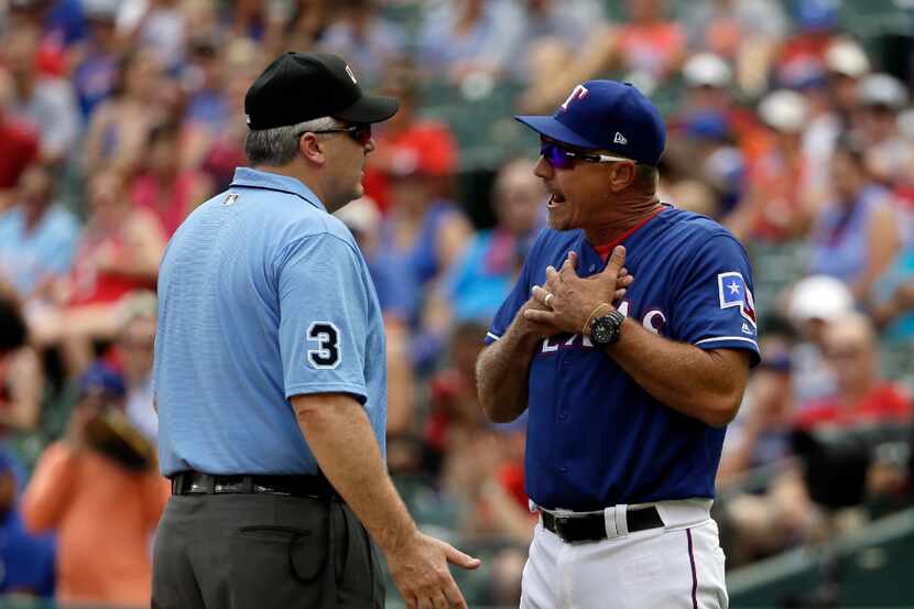 Crew chief Bill Welke, left, listens as Texas Rangers manager Jeff Banister argues after...