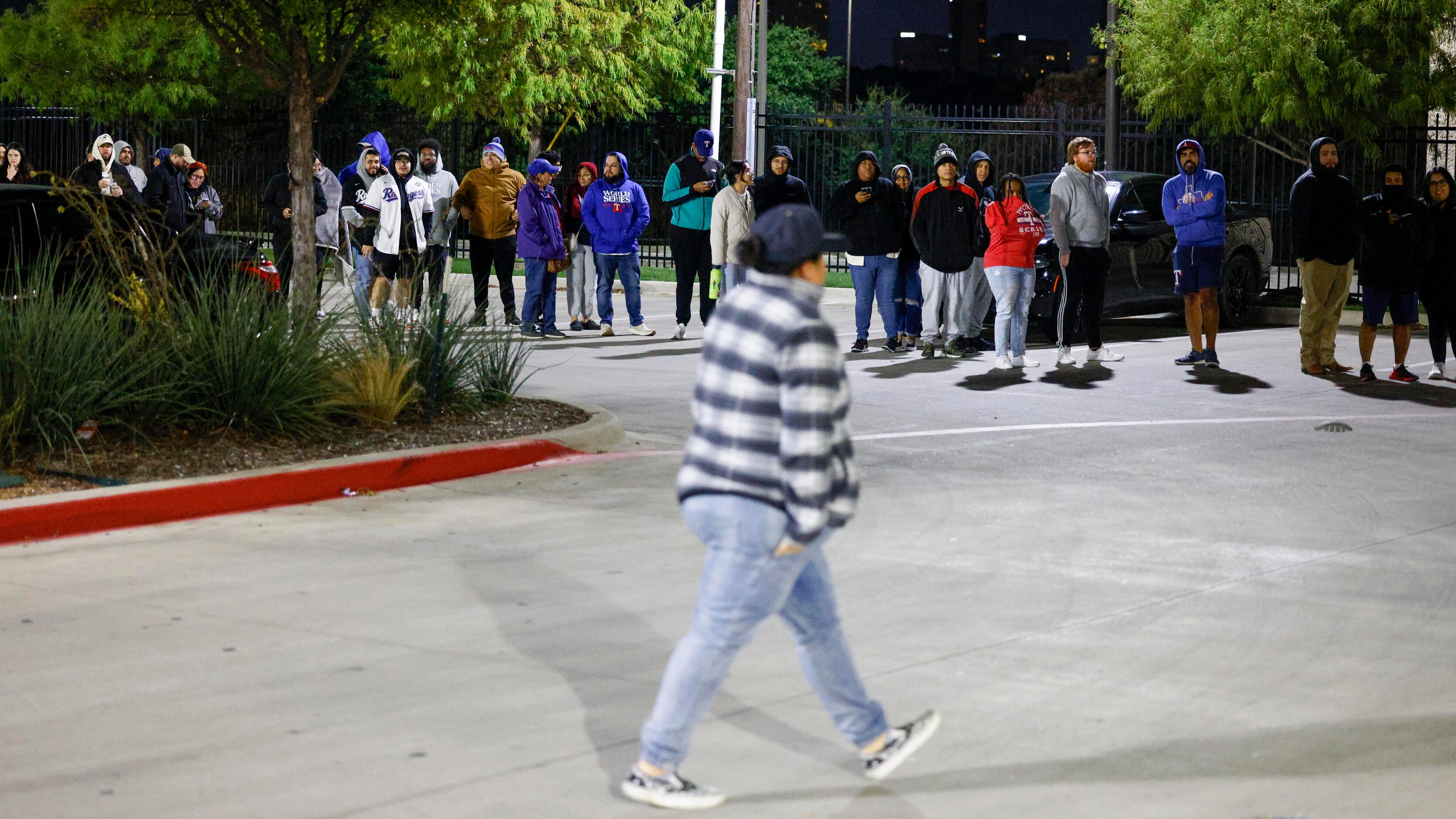 A line of people wraps around the parking lot of an Academy Sports as they wait to buy Texas...