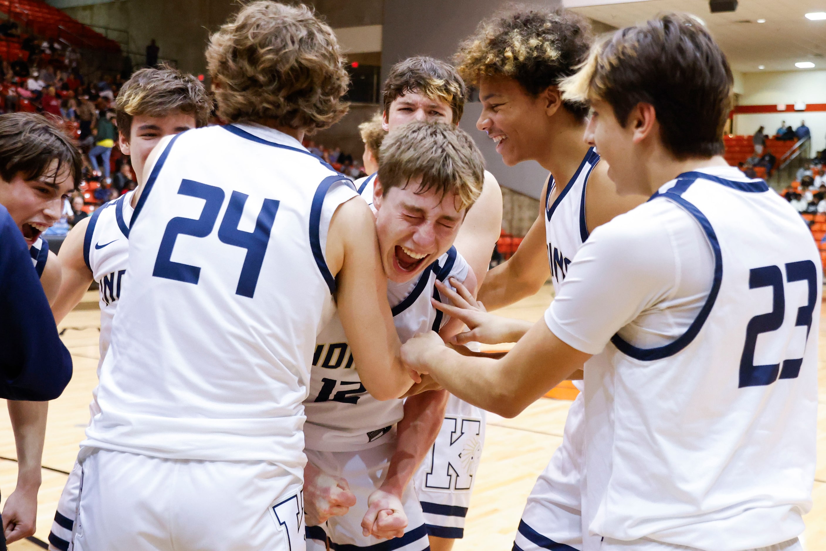 Keller High players cheer surrounding Rhett Schank (center) following their win in the Class...