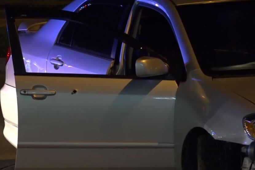 A bullet hole is visible in the passenger-side door of a Toyota Corolla that was struck by...