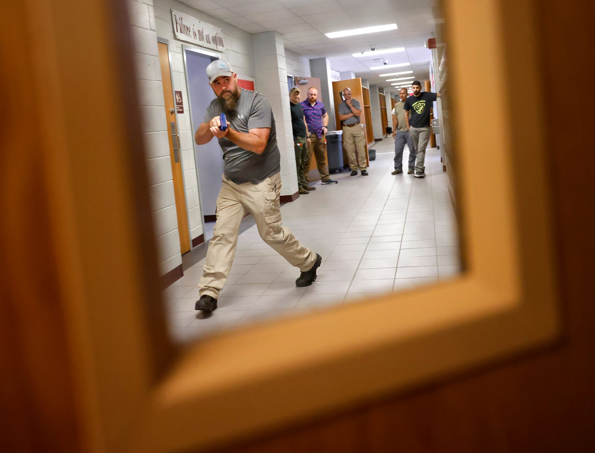 Henderson County Sheriff’s Deputy Kenneth Slaton
approaches an open classroom door as they...