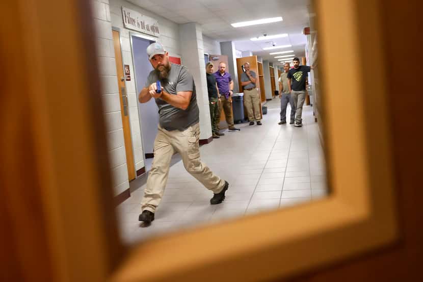 Henderson County Sheriff’s Deputy Kenneth Slaton
approaches an open classroom door as they...