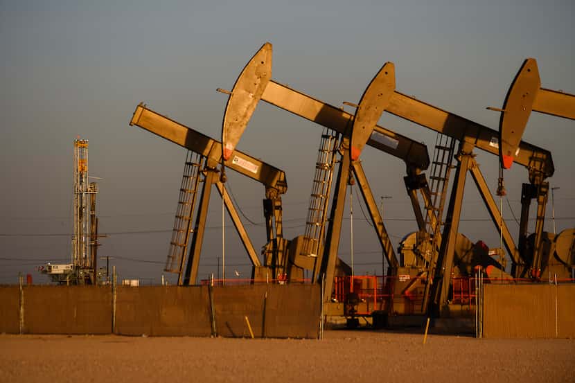 An array of pumpjacks operate near the site of a new oil and gas well being drilled April 8,...