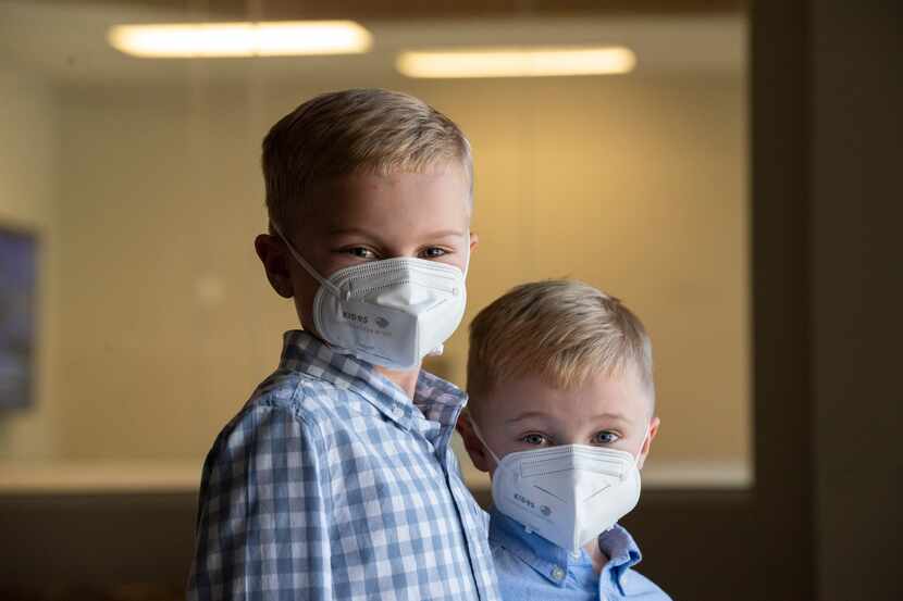 William Bielamowicz, 8, left, and his little brother Matthew, 6, wear KID95 masks designed...