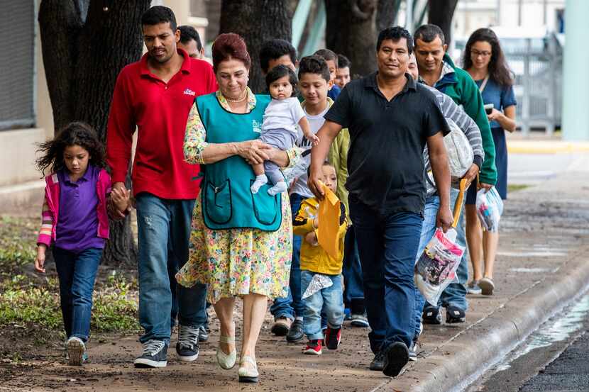 Volunteer Blanca Munoz carried 5-month-old Selene as she walked with the baby's father,...
