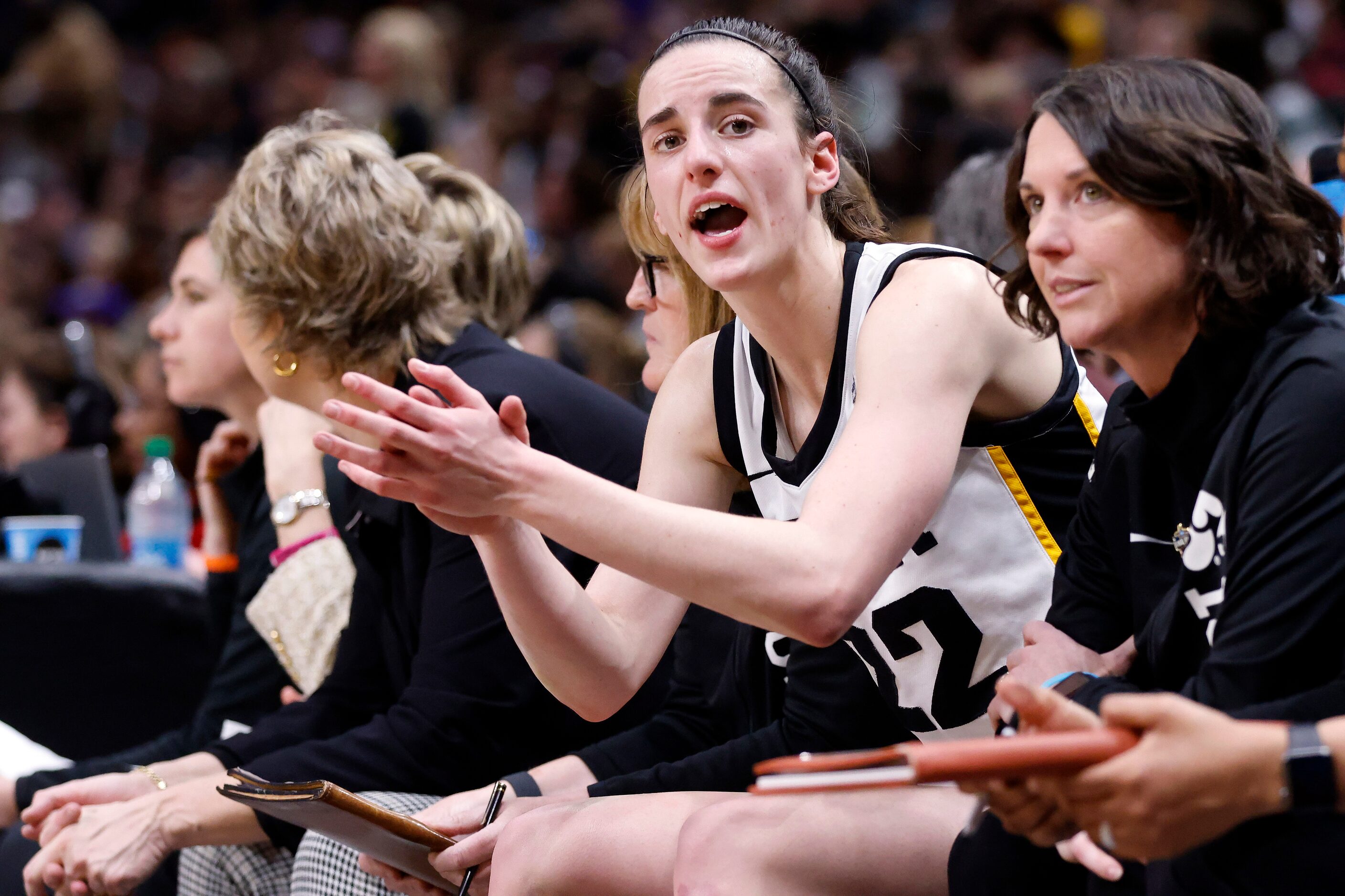 Iowa Hawkeyes guard Caitlin Clark (22) applauds her teammates as she comes out of the game...