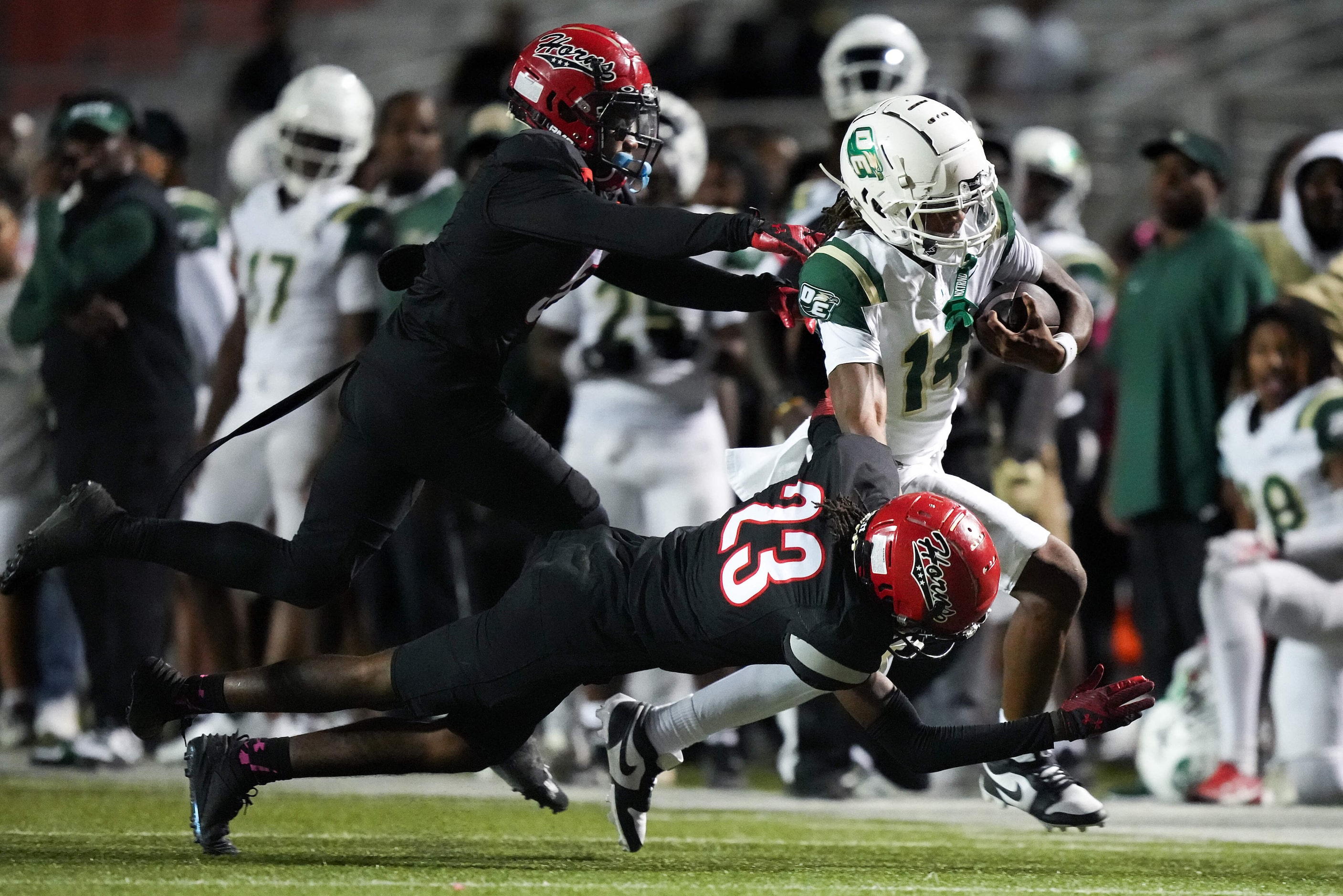 DeSoto quarterback Legend Howell (14) is pushed out of bounds by Cedar Hill defensive back...