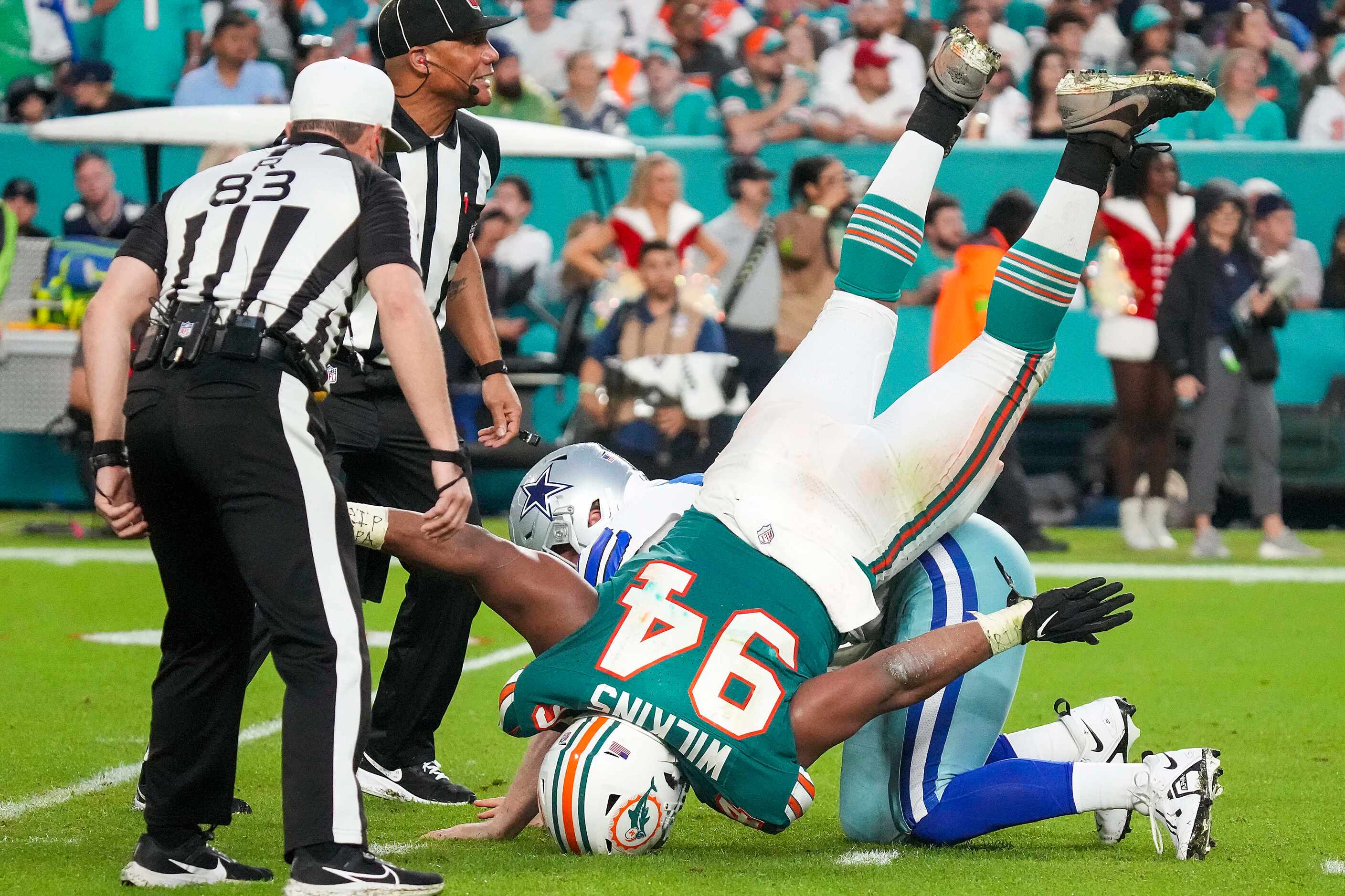 Miami Dolphins defensive tackle Christian Wilkins (94) tumbles over Dallas Cowboys long...