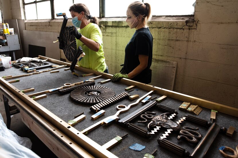 Restoration technicians Allison Savage (left) and Jessica Thomas work on pieces of bronze...