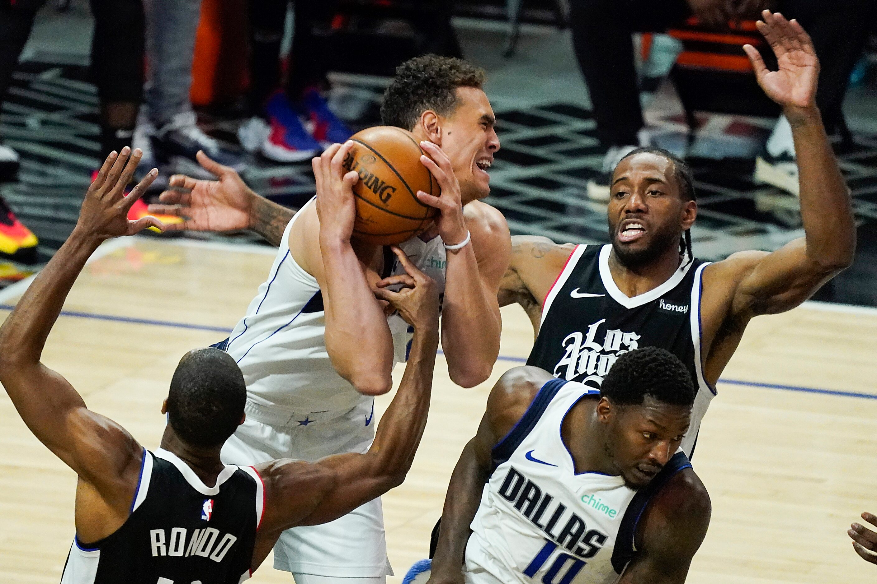 Dallas Mavericks center Dwight Powell (7) grabs a rebound from LA Clippers guard Rajon Rondo...