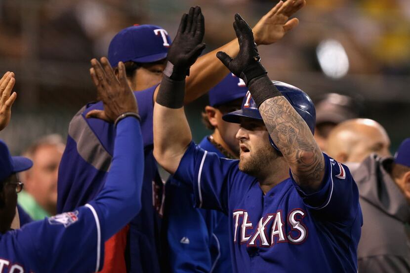 OAKLAND, CA - OCTOBER 01: Mike Napoli #25 of the Texas Rangers is congratulated by teammates...