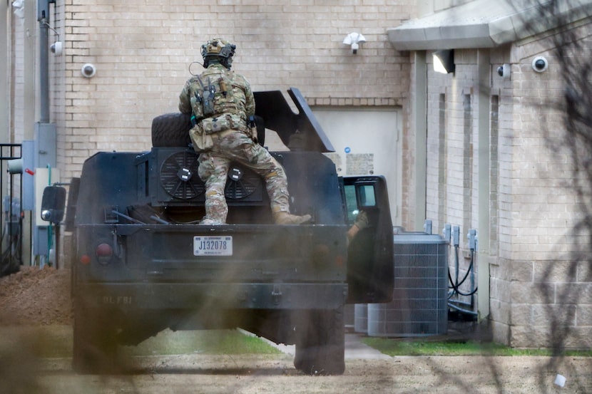 A law-enforcement officer covers an entrance to Congregation Beth Israel in Colleyville on...