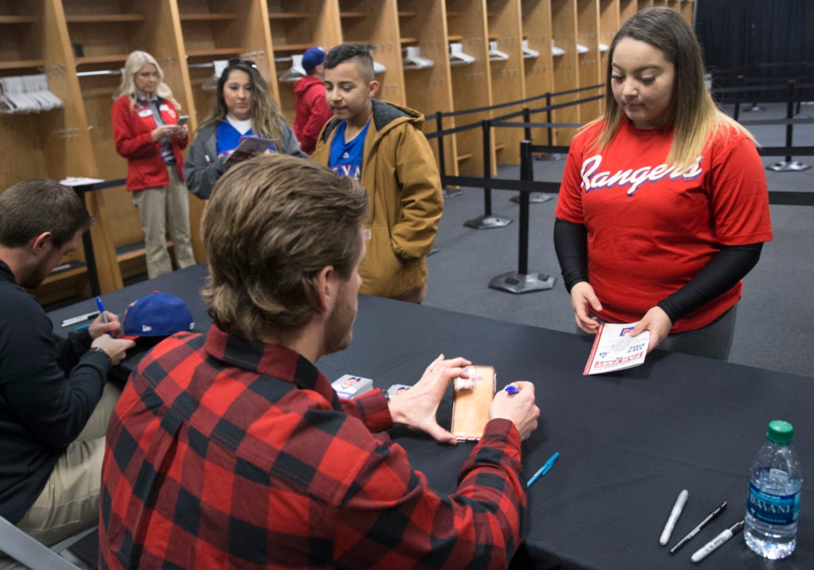 Elena Luera of Fort Worth watches as Texas Ranger Patrick Wisdom signs her cellular phone...