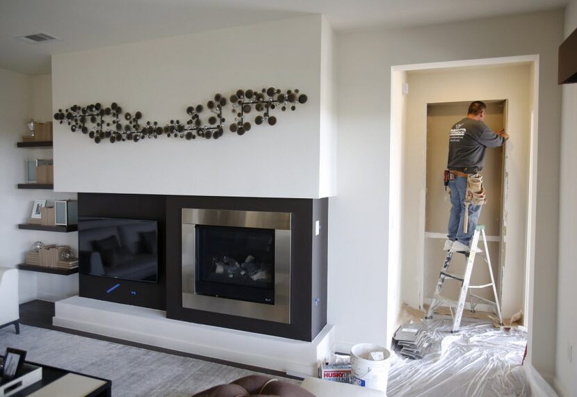 Jose Garcia of Dallas works on sheetrock inside a MainVue Homes Geneva Q1 model home at...