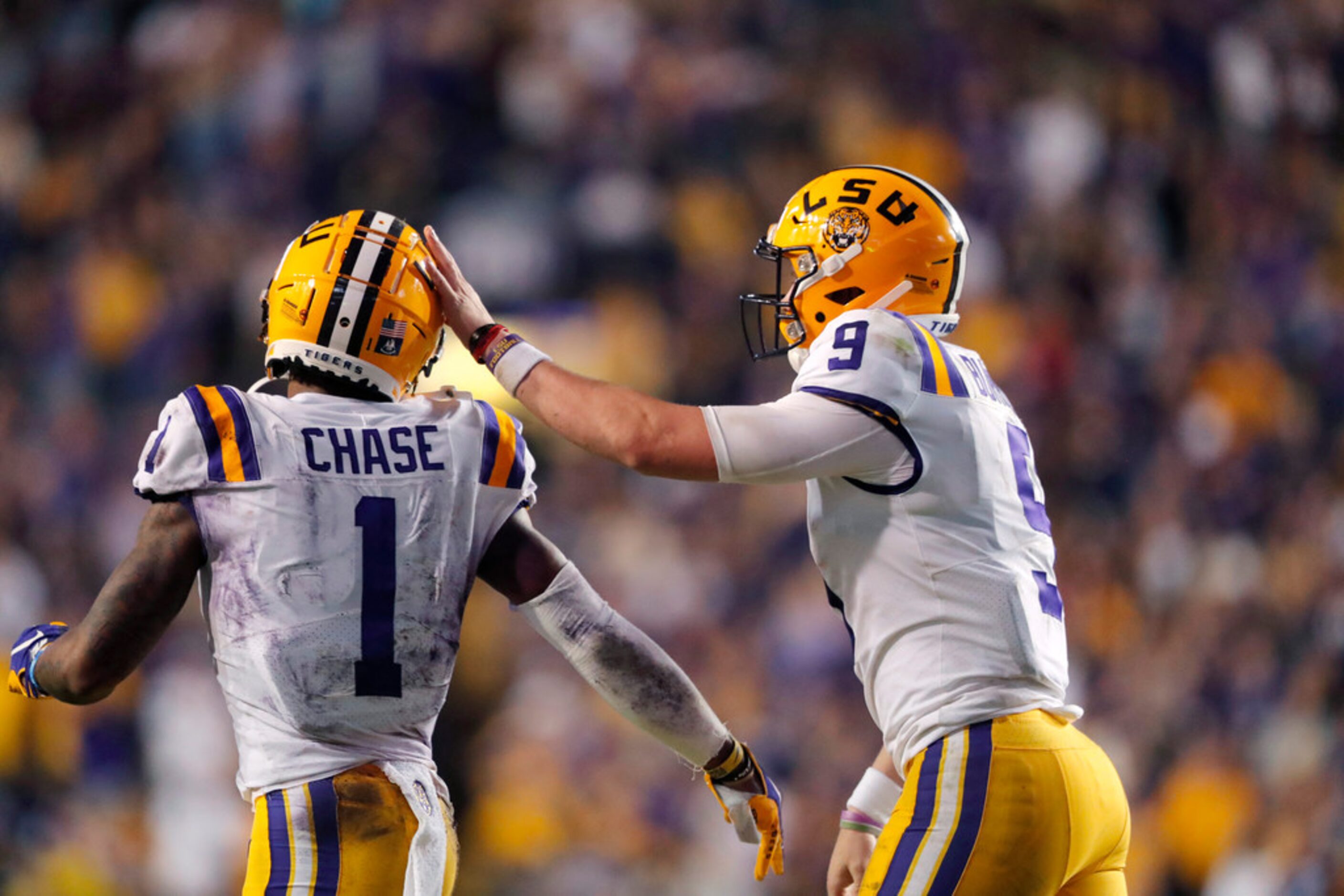 LSU quarterback Joe Burrow (9) celebrates with wide receiver Ja'Marr Chase (1) on their...