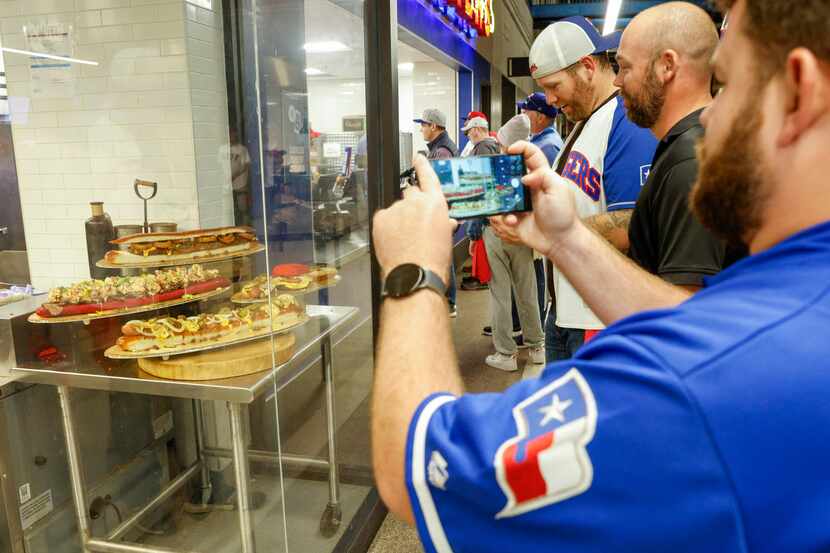Texas Rangers fans take photos of the $250 set of three sandwiches before Game 2 of the...