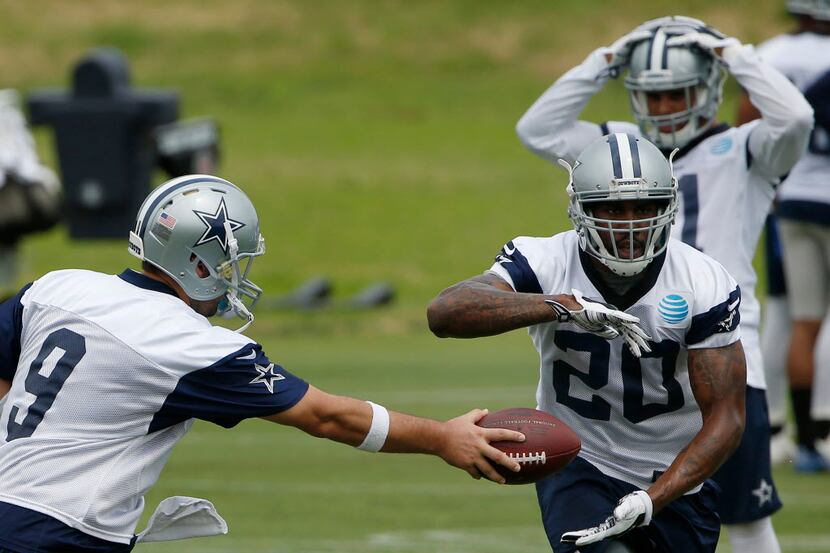Dallas Cowboys quarterback Tony Romo (9) hands the ball off to running back Darren McFadden...