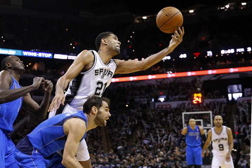 San Antonio Spurs forward Tim Duncan (21) reaches for an offensive rebound with Dallas...