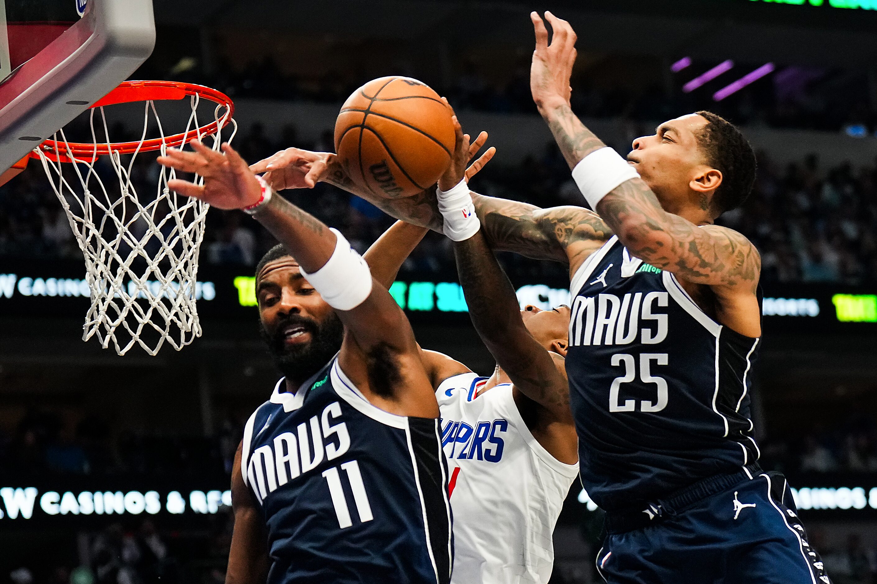 Dallas Mavericks guard Kyrie Irving (11) and forward P.J. Washington (25) defend a shot by...