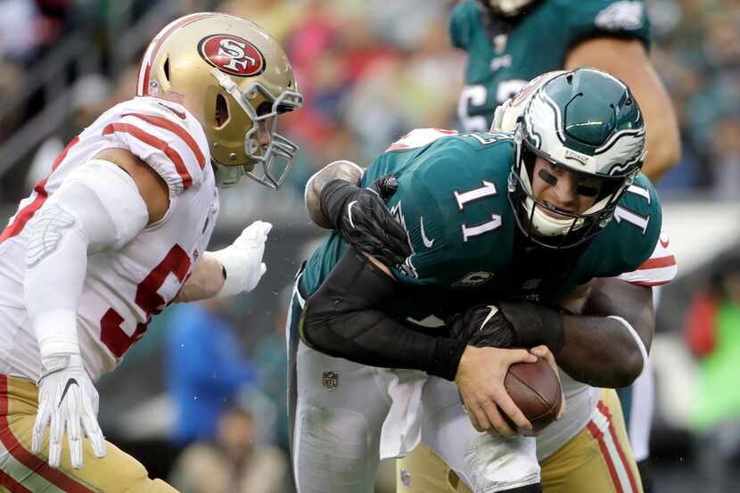 Philadelphia Eagles' Carson Wentz (11) is tackled by San Francisco 49ers' Earl Mitchell (90)...