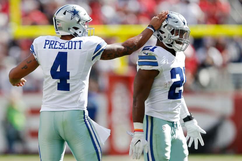 Dallas Cowboys quarterback Dak Prescott (4) taps the helmet of Dallas Cowboys running back...