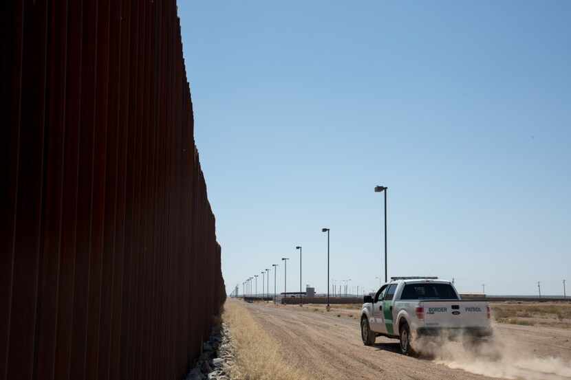 A U.S. Border Patrol agent drives along the fence separating Columbus, N.M. from Puerto...
