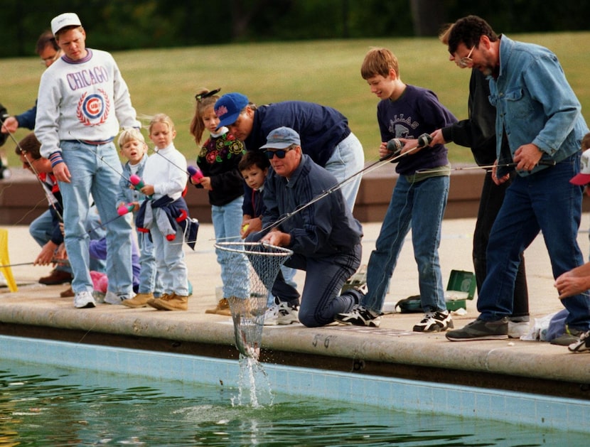 Fellow anglers watch as Ryan  DeNamur, 13 (in the Dallas Cowboys shirt), catches a catfish ...