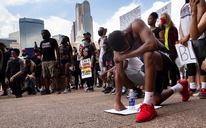 Ryan Hunter from Fort Worth kneels at Dallas City Hall after peacefully marching through...