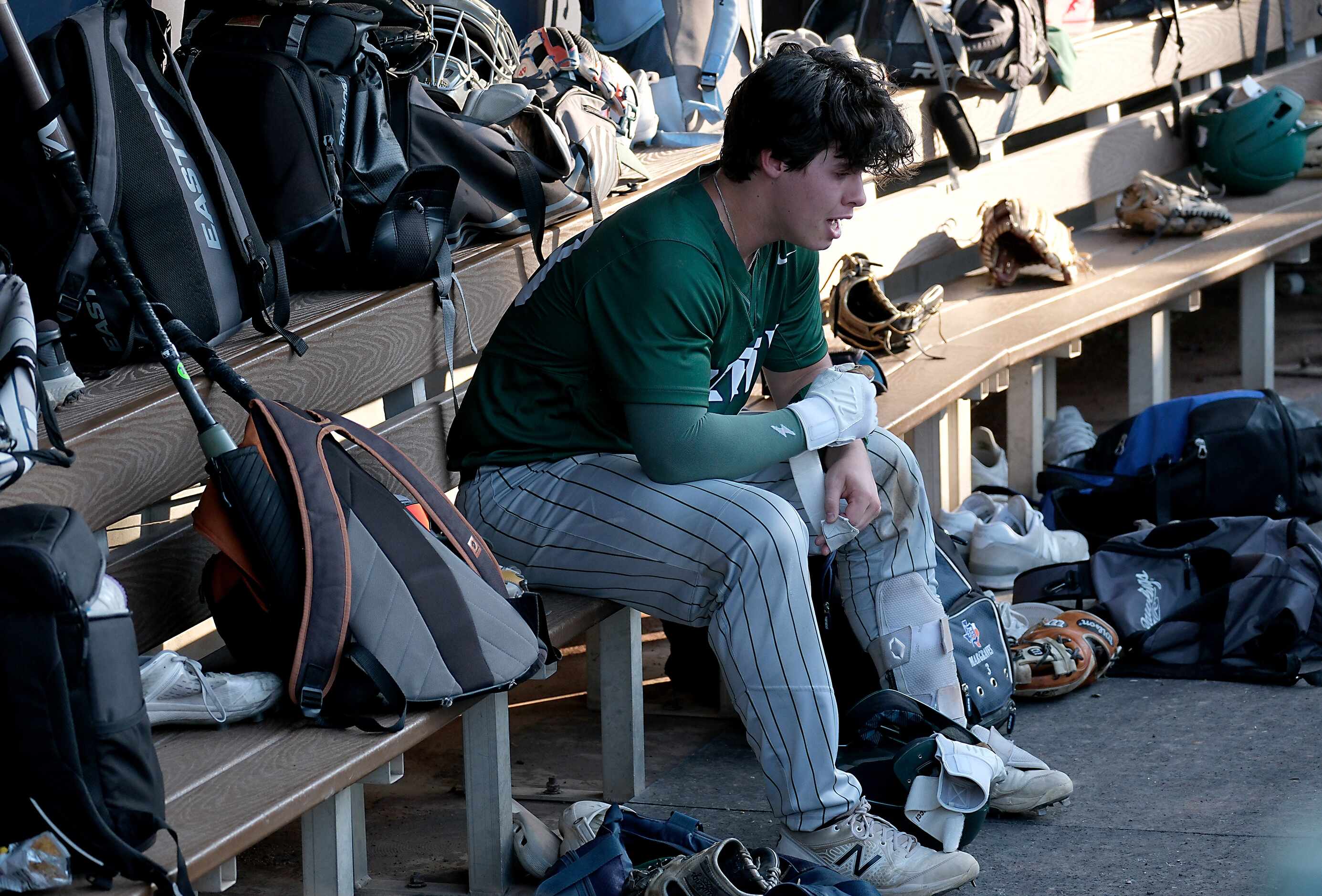 Frisco Reedy Caden Jones, (23), overcome with emotion sits on the team bench after hitting a...