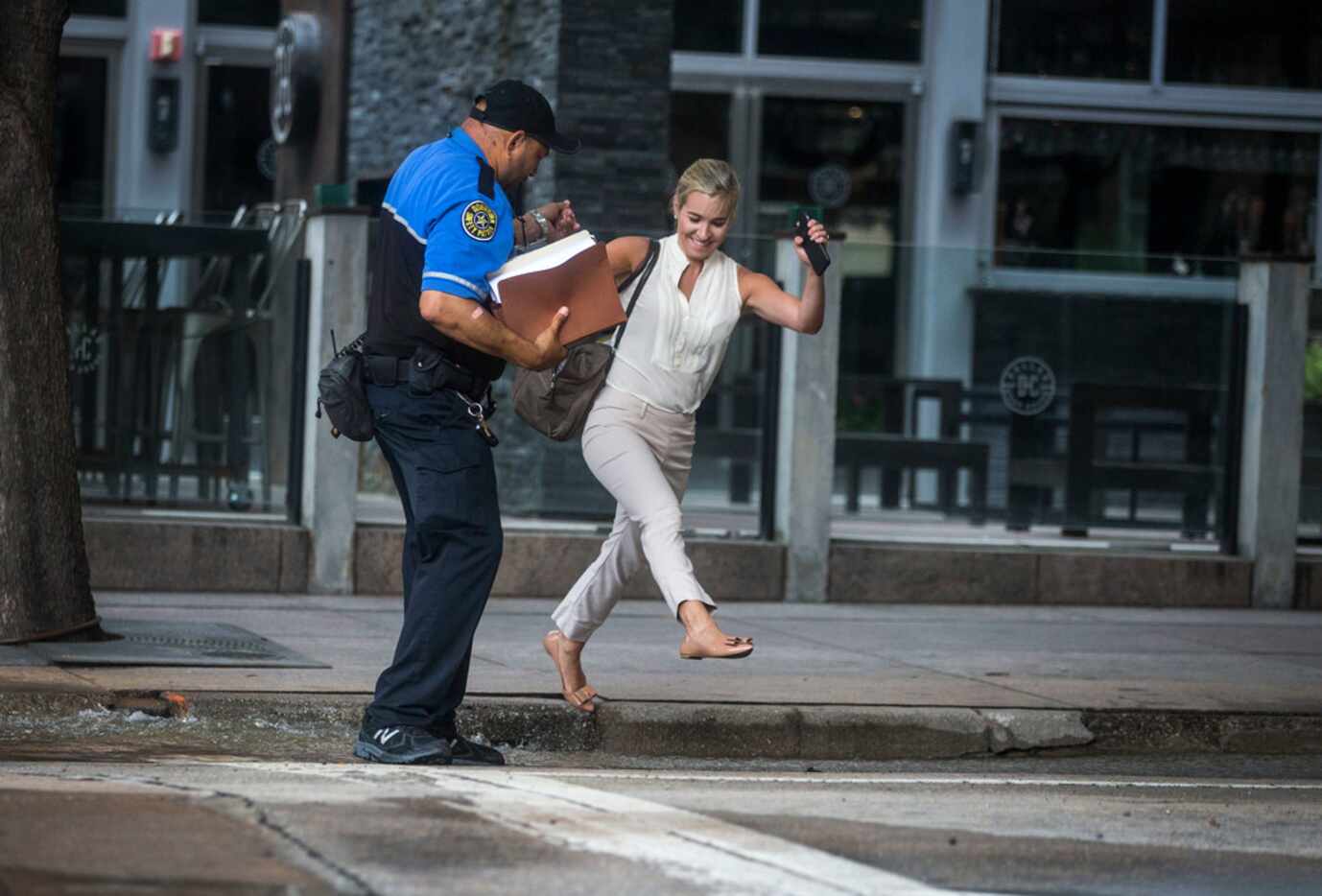Wendell Kinney, a downtown Dallas safety patrol officer, helps Kristen Zeigler of Dallas...