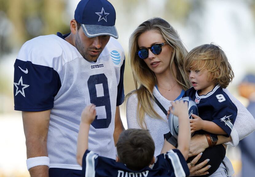 Dallas Cowboys quarterback Tony Romo (9) and his wife  Candice Crawford corral their kids...
