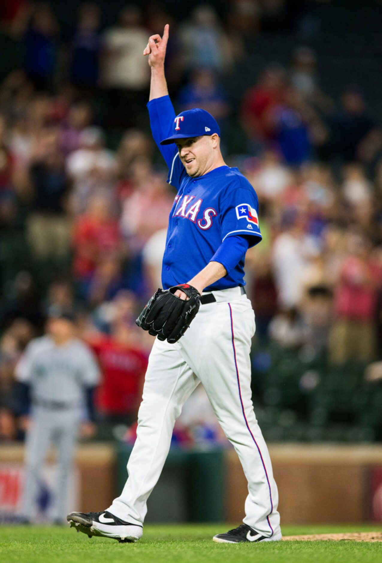 Texas Rangers relief pitcher Shawn Kelley (27) signals a foul ball hit by Seattle Mariners...