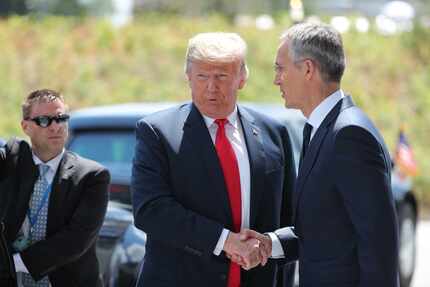 President Donald Trump shakes hands with NATO Secretary General Jens Stoltenberg as he...