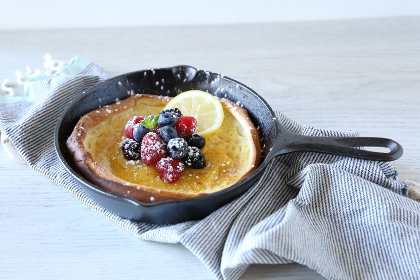 Sweet Dutch baby pancake with lemon curd, berries and powdered sugar