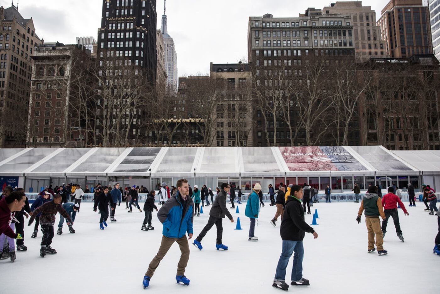People skate on a temporary ice rink set up in Bryant Park as part of a winter carnival in...