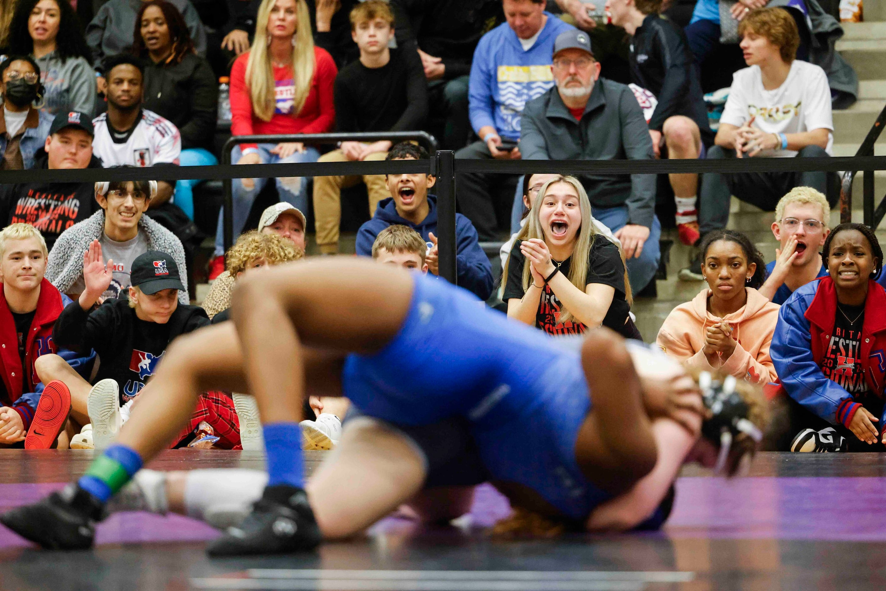 Crowd cheers as they watch Eve Smith of Midlothian Heritage wrestle against Layla Asana of...