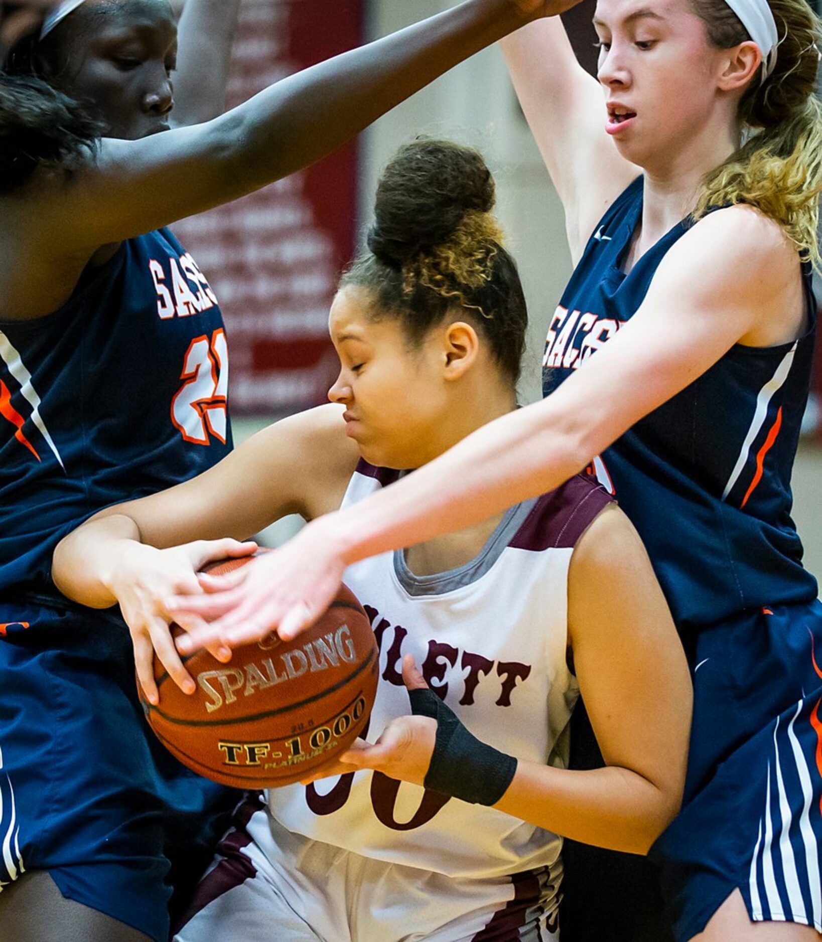 Sachse center Adhel Tac (23) and guard Avery Crouse (5) trap Rowlett guard Mallorie Miller...