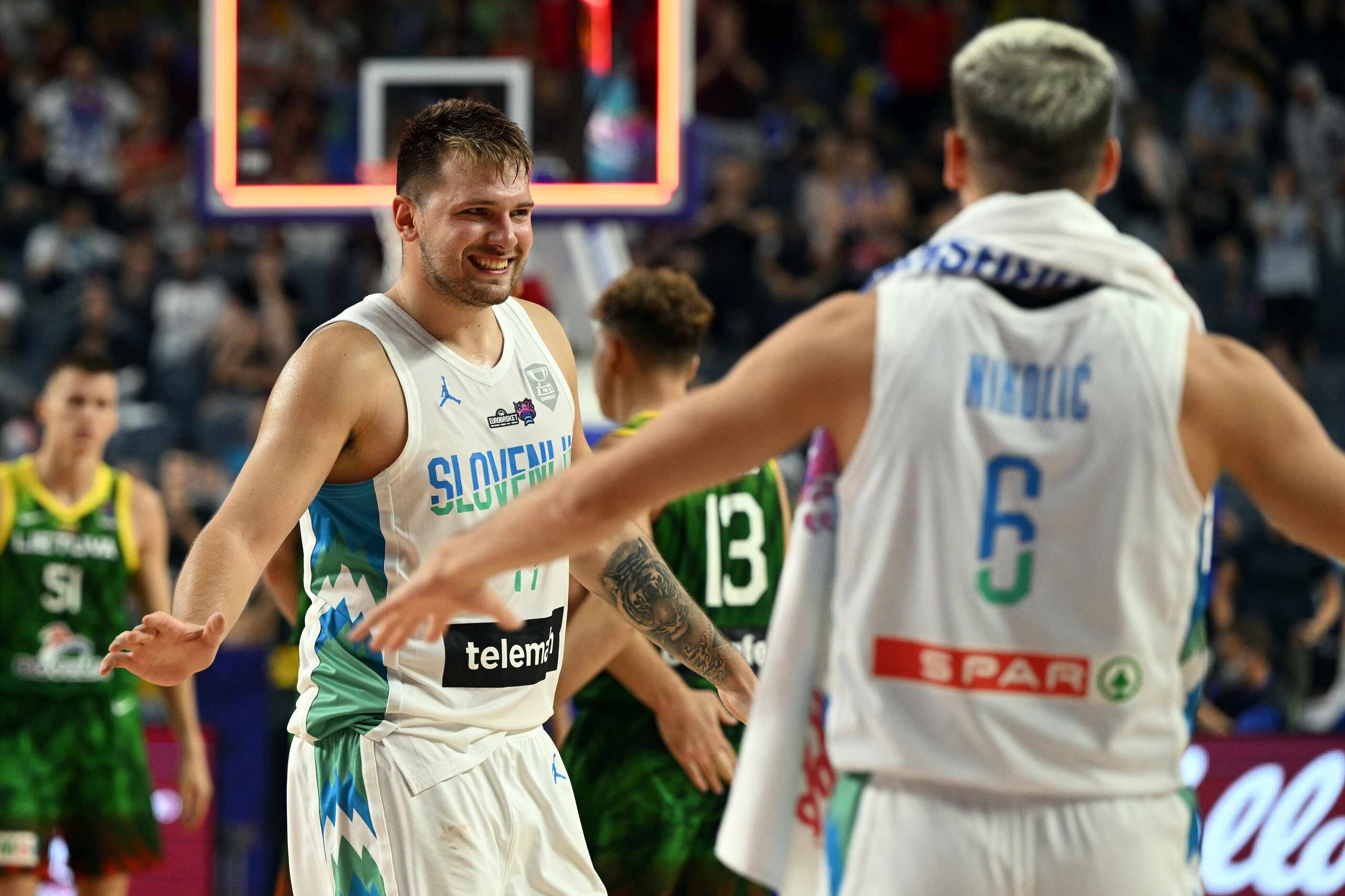 Slovenia's Luka Doncic, left, celebrates his team's victory during the Eurobasket group B...