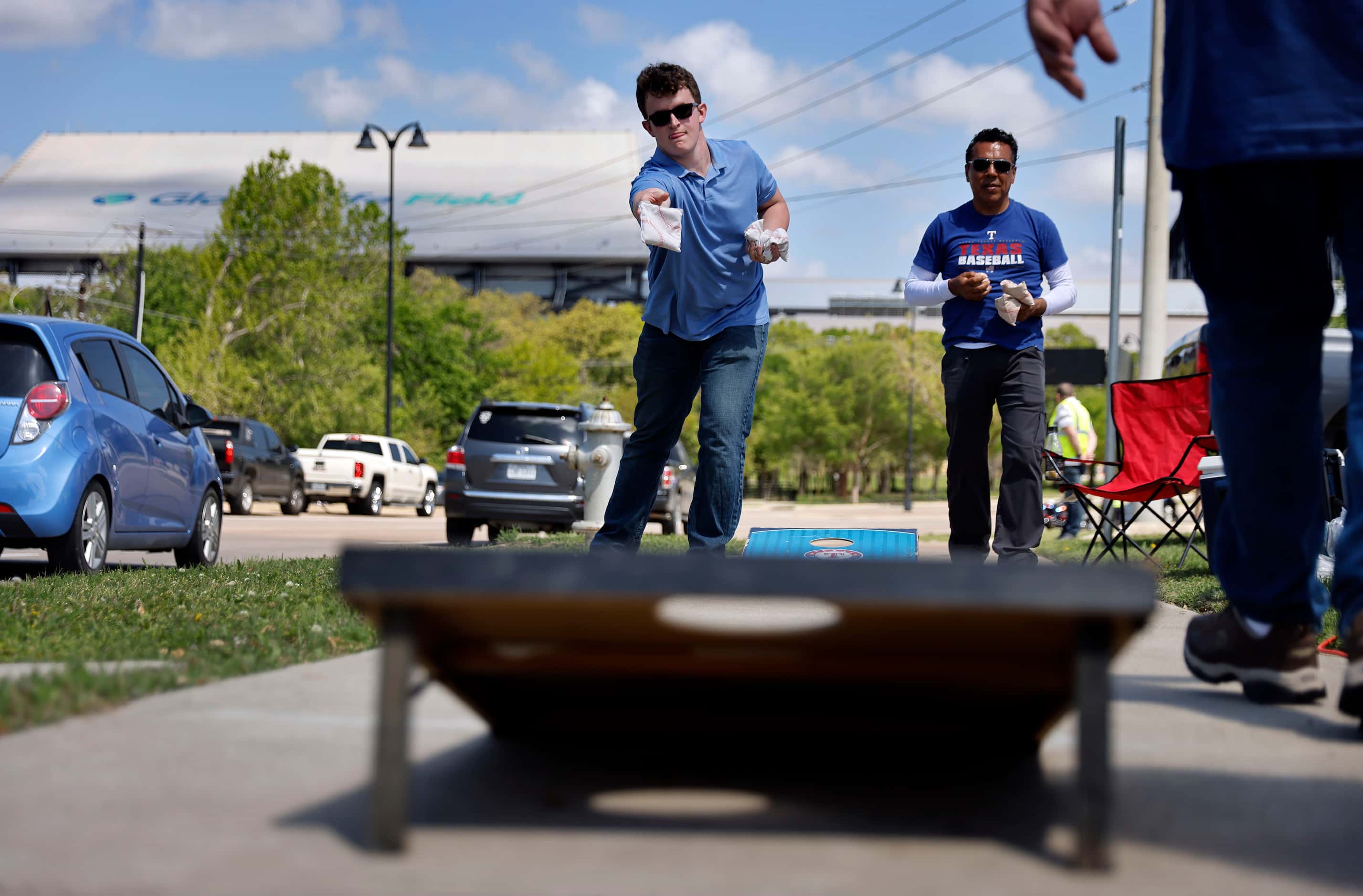 Texas Rangers fans Jack West (left) and Abney Herrera of Pantego play corn hole during an...