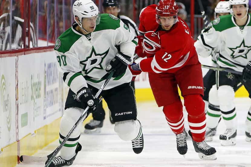 Dallas Stars' Jason Spezza (90) looks to pass the puck with Carolina Hurricanes' Eric Staal...