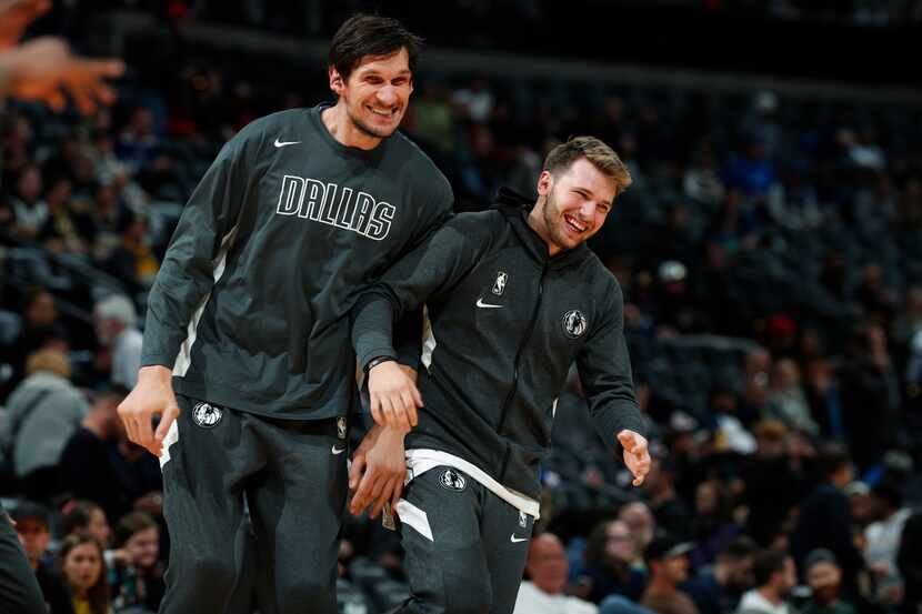 Mavericks center Boban Marjanovic (left) jokes with guard Luka Doncic as they warm up before...