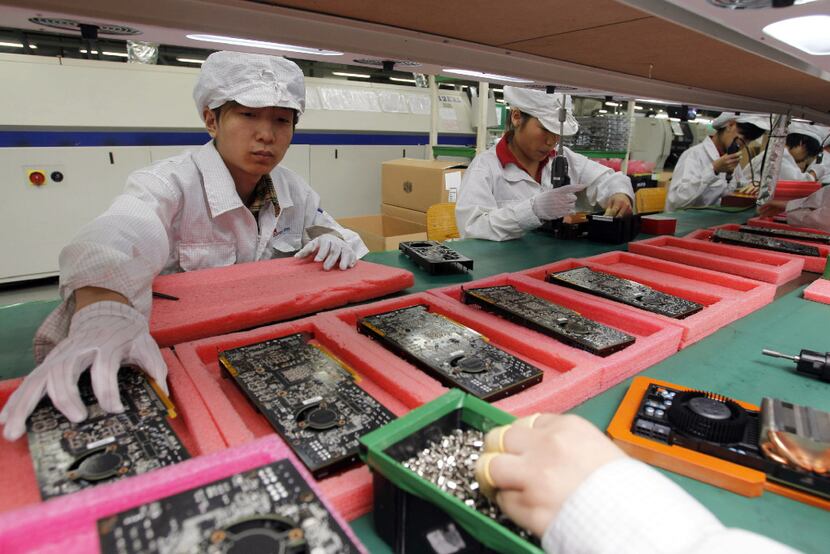Staff members work on the production line at the Foxconn complex in the southern Chinese...
