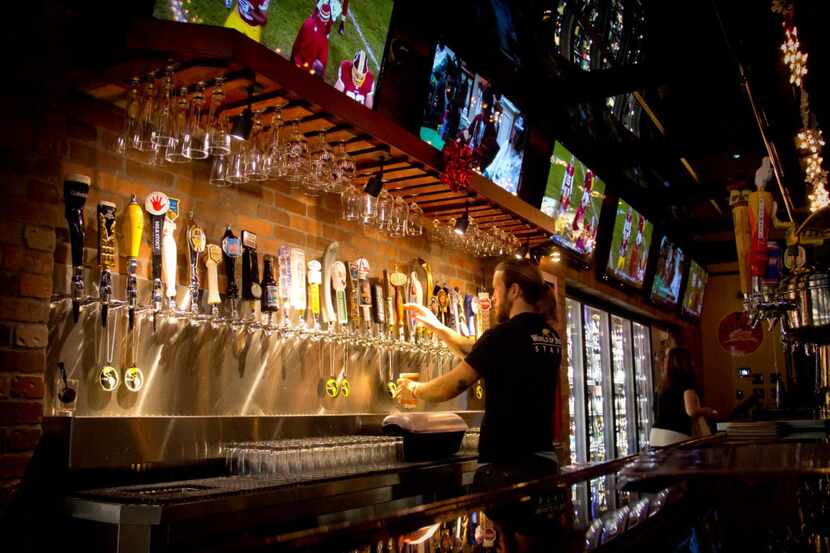 Bartender Matt Cook draws a draft from the wide selection of craft beers on tap at World of...