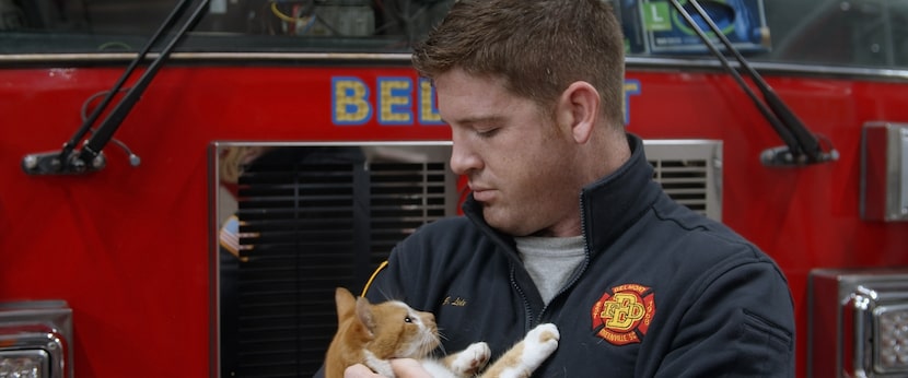 A fire engineer holds Flame, who is taken care of by the Belmont Fire Department in...