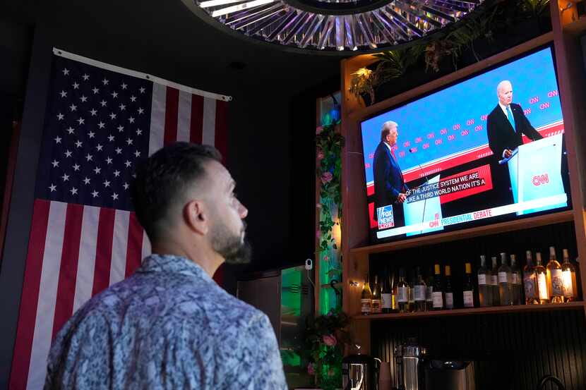 A patron watches President Joe Biden debate Republican presidential candidate and former...