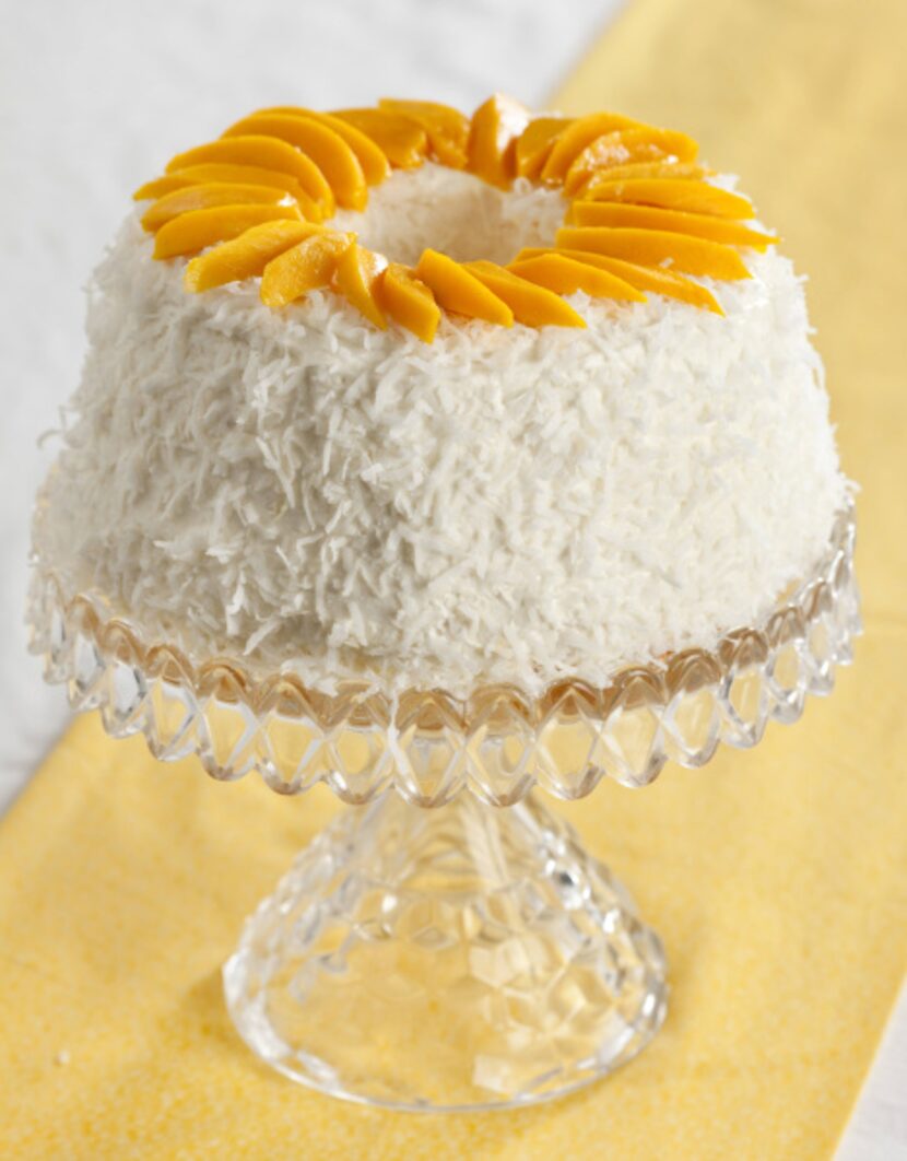 A sunny ring of mango slices adorns the top of the Peach and Mango Coconut Cream Cake.