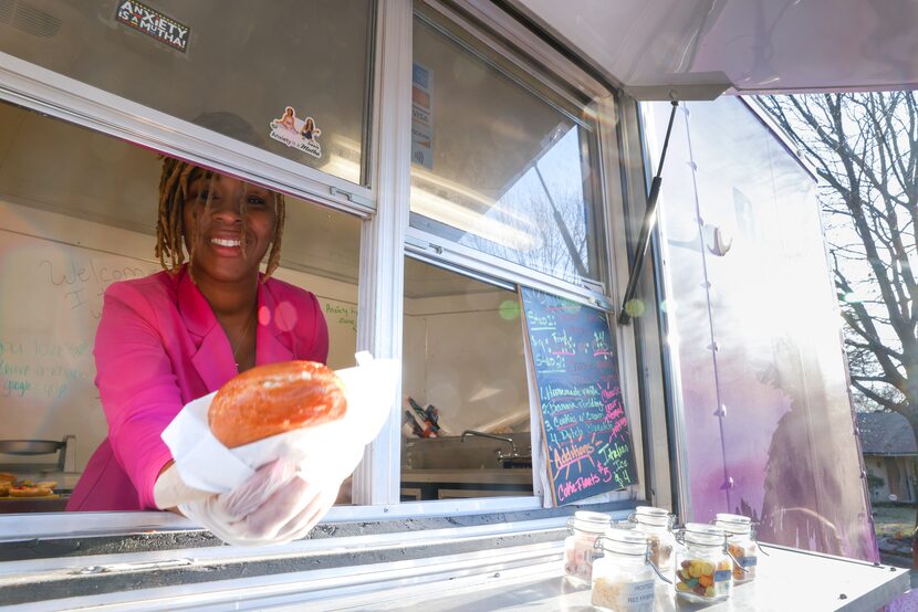 Owner Nikita Seal delivers an ice cream puff out the window of ZZ's Ice Cream Puffs food...