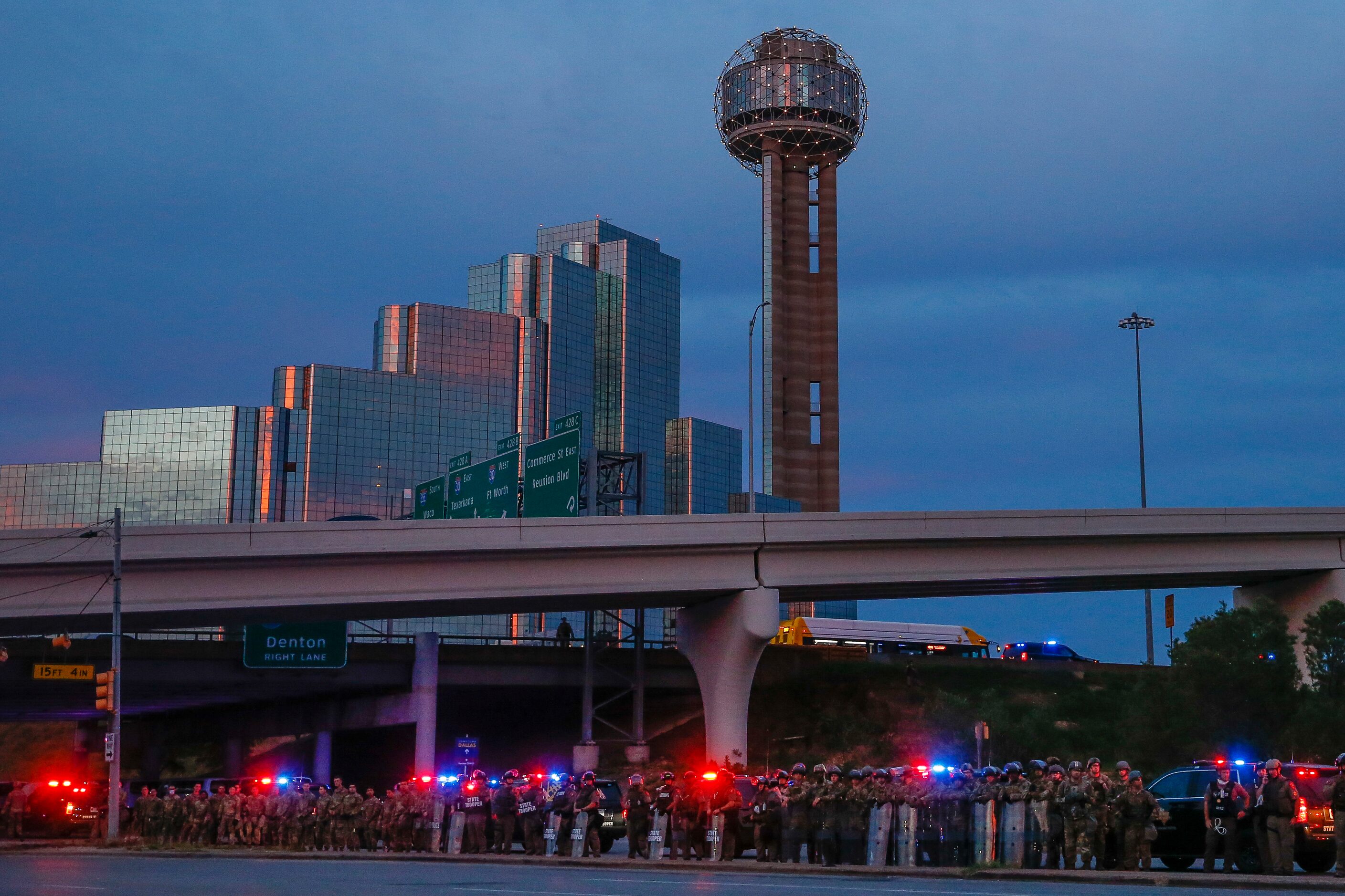 Police and the National Guard stage as protesters prepare to march to the Margaret Hunt Hill...