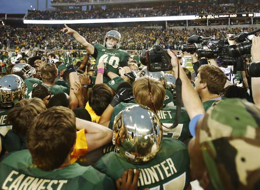 Baylor Bears place kicker Chris Callahan (40) is hoisted in the air after successfully...
